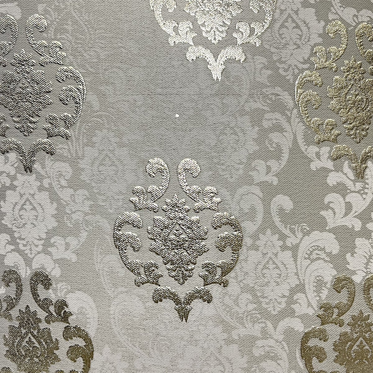 Close-up of the damask weave and gold-toned motifs in light grey